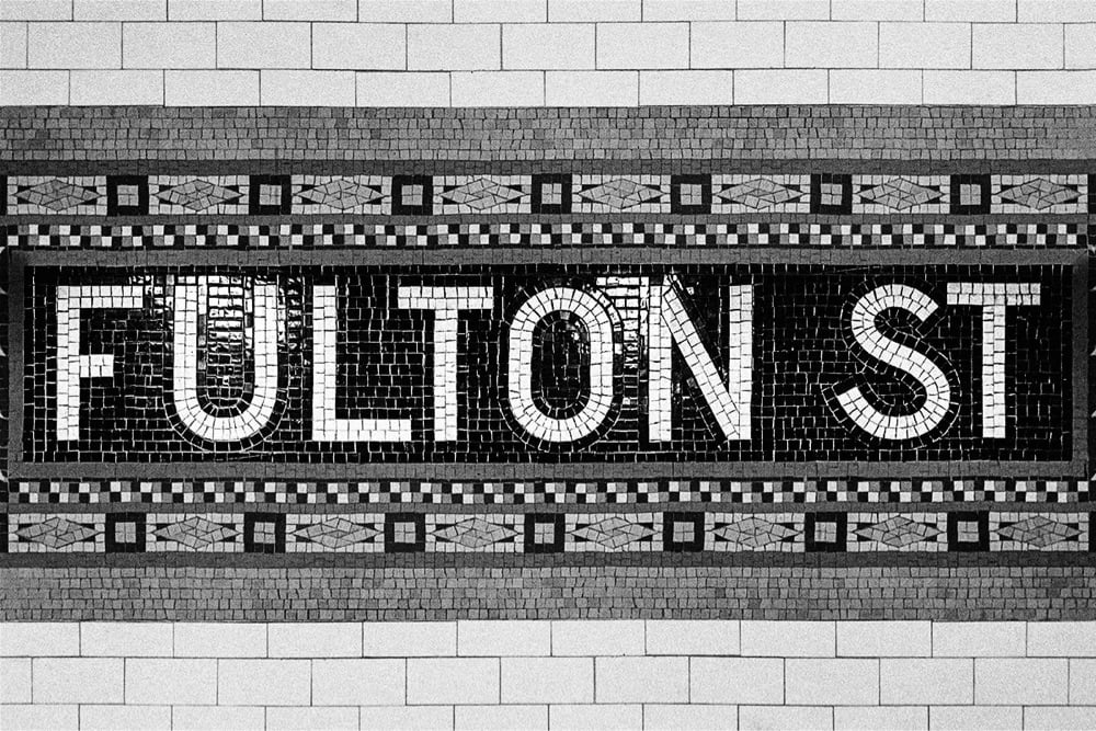 a sample of the mosaic tile lettering found in NYC subway stations. This one reads 'Fulton St'.